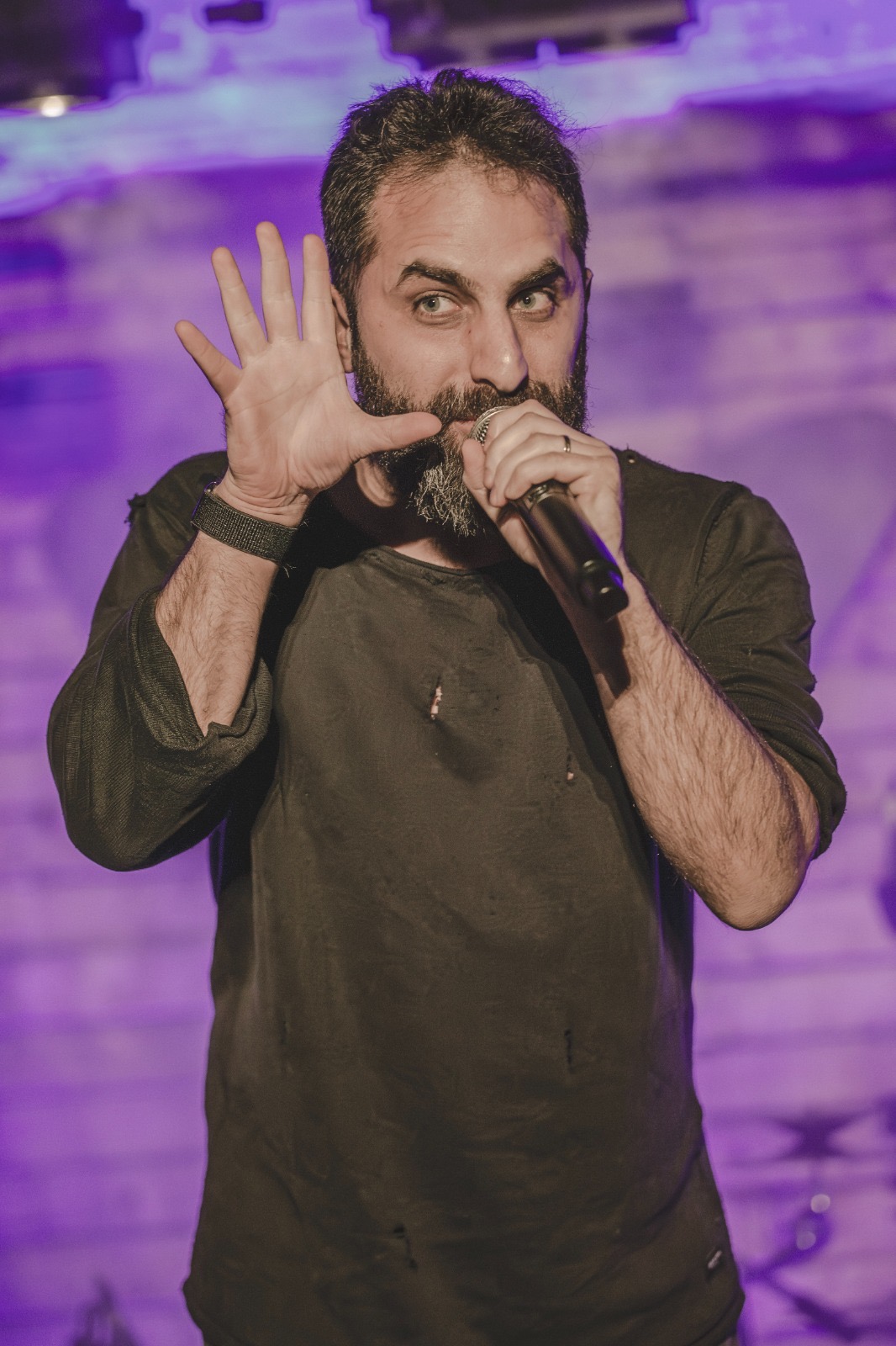 Chris Khatsch, burnout recovery and creative living coach from Lebanon, performing with his band In Sanity Q on stage.